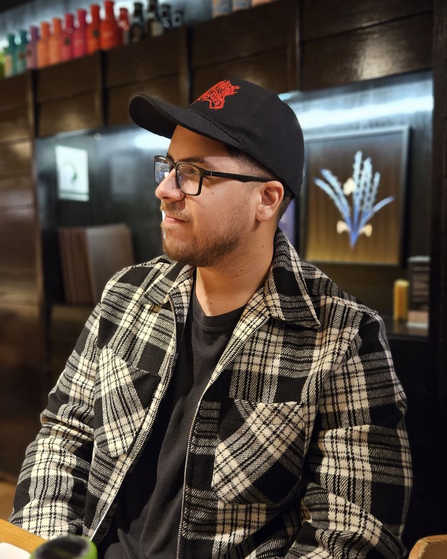 Pablo in a restaurant in Bogotá, wearing a cap and a plaid jacket