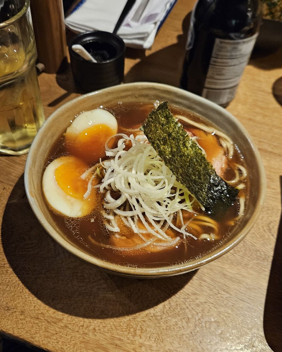 A bowl of ramen with egg and nori