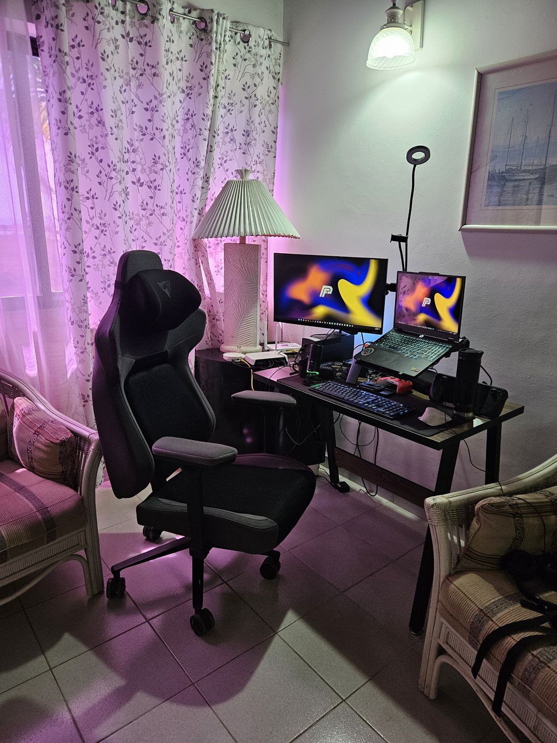 Pablo's desk with a monitor and a laptop showing his PF logo, a gaming chair and a ring light
